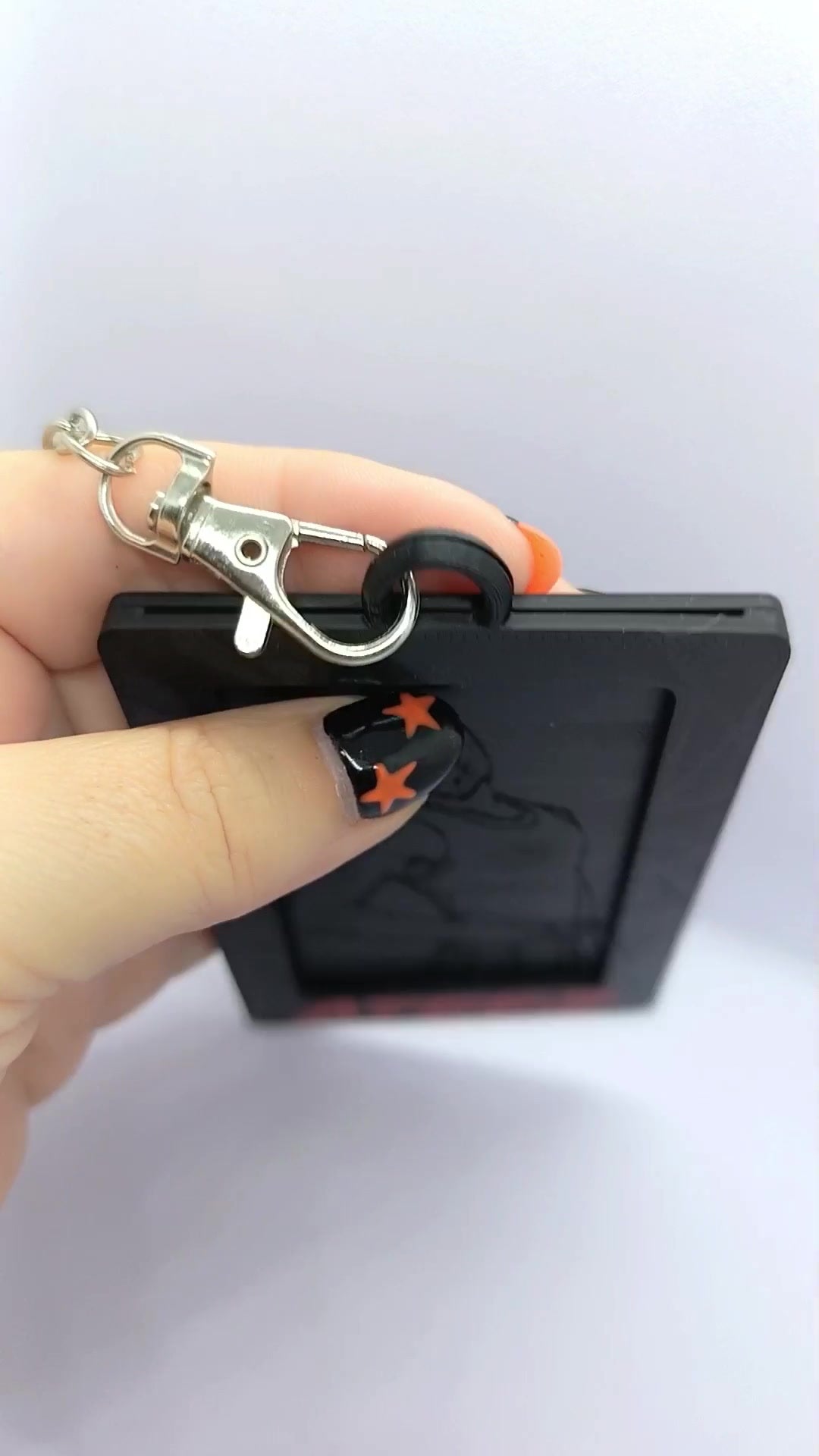 Detalle de la anilla, cadena y mosquetón del holder para photocard ATEEZ BAD.