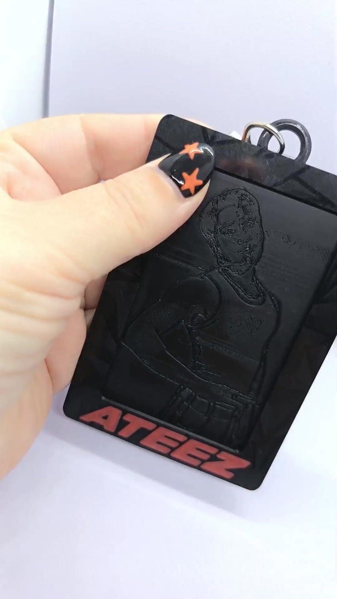 Holder para photocard ATEEZ BAD negro impreso en 3D, vista frontal con nombre ATEEZ rojo y marco geométrico.