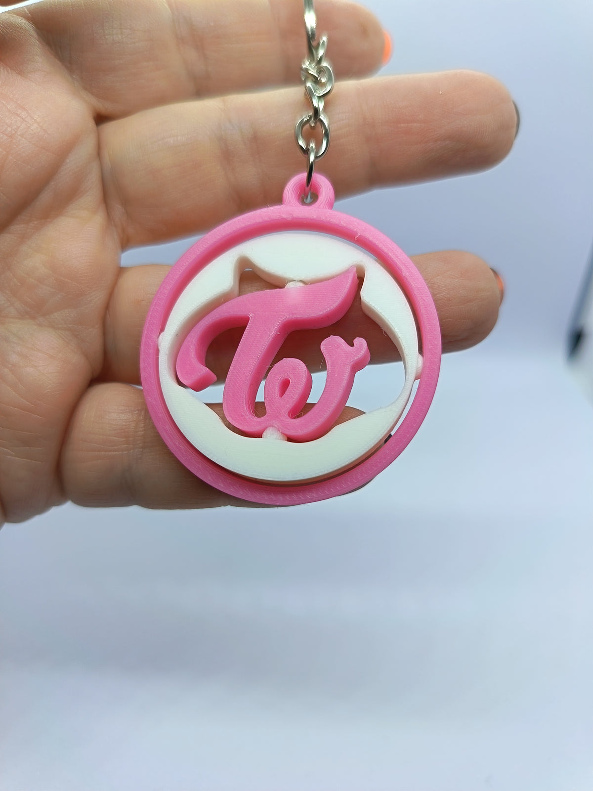 Llavero TWICE con logo giratorio rosa, fotografía 1 del producto.